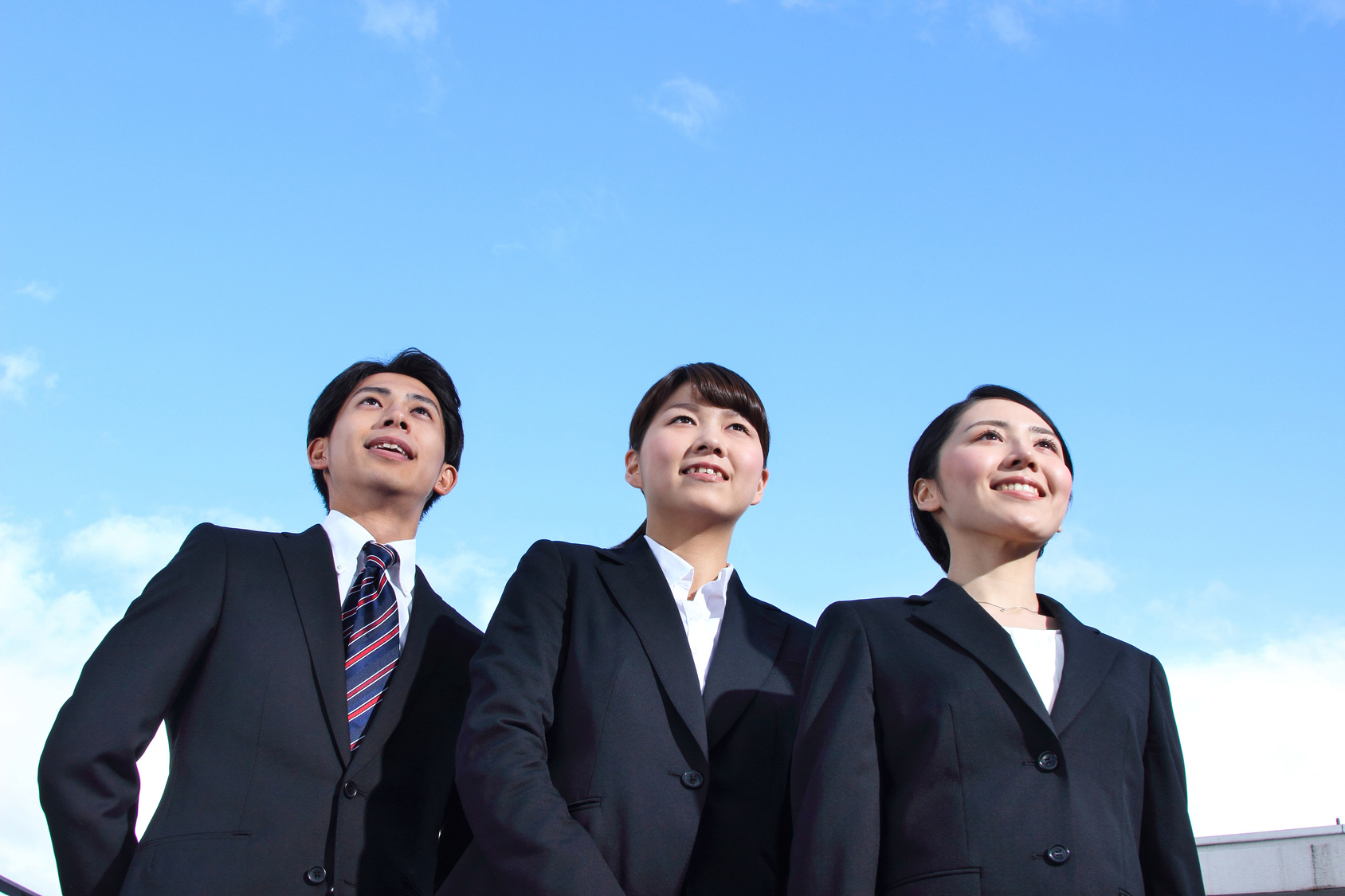 Asian businessman and businesswoman looking up at the sky